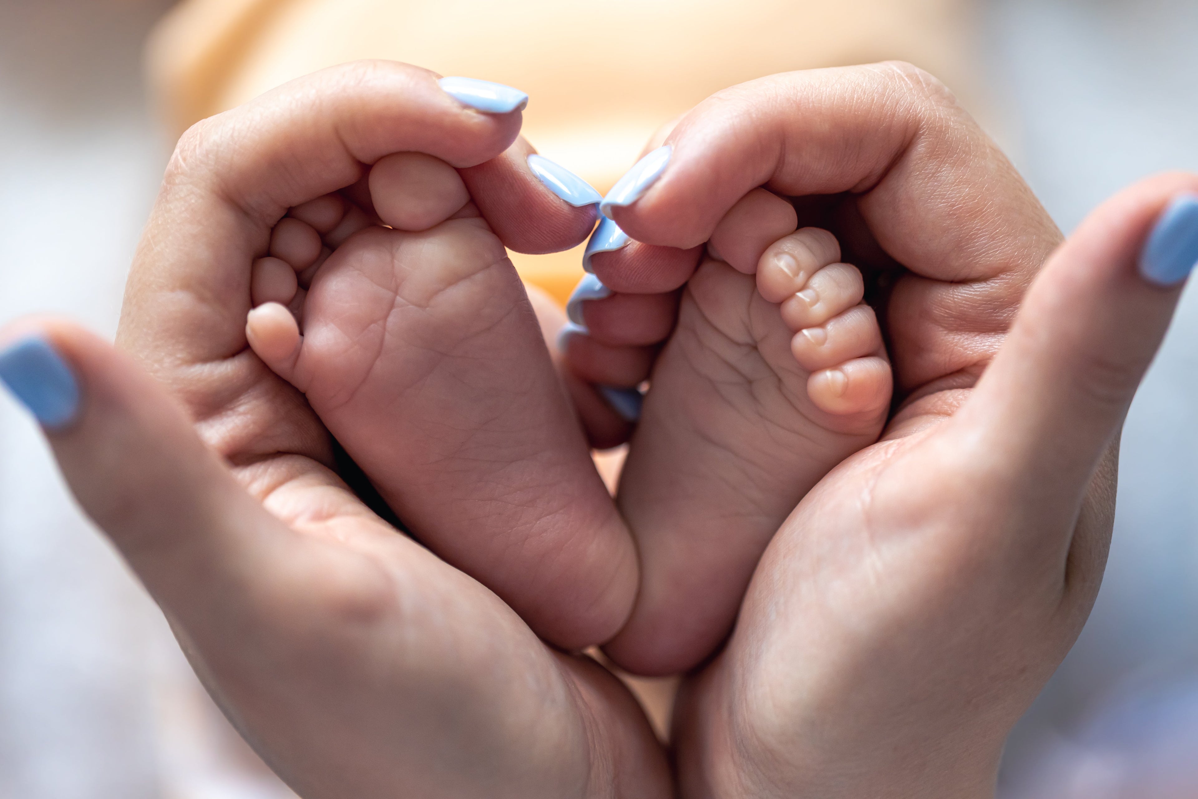 Baby voetjes vastgehouden door een mama